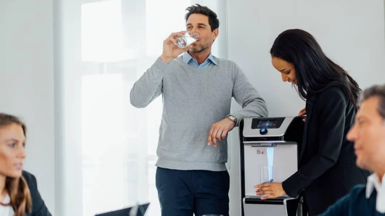 Man drinking water and woman dispensing water from the Q9 bottleless water cooler